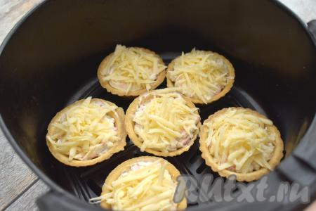 Тарталетки с крабовыми палочками ставим в чашу аэрогриля. Отправляем чашу в аэрогриль.