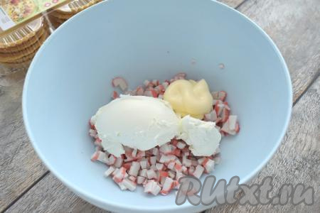 В миску с нарезанными крабовыми палочками добавляем творожный сыр и майонез.