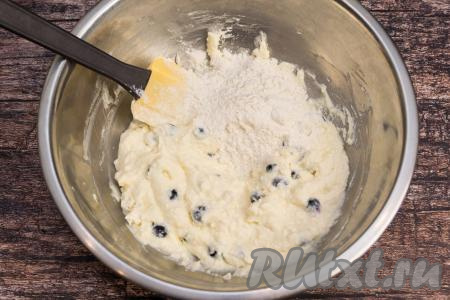 Аккуратно подмешать ягоды лопаткой, равномерно распределяя их по творожной массе. Начать добавлять по половине столовой ложки муки, каждый раз полностью вмешивая её.