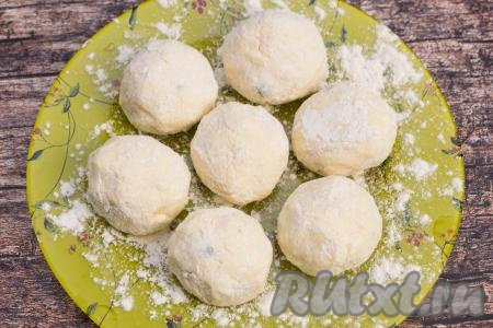 Заготовки сырников с замороженными ягодами выкладывать на плоскую тарелку, припылённую мукой. Постепенно сформировать все 7 сырников.