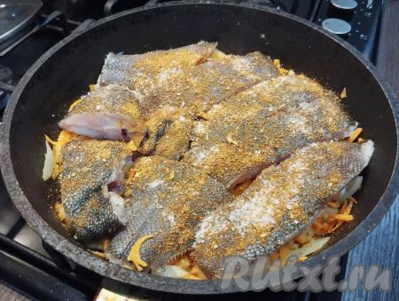 Выкладываем кусочки камбалы, добавляем соль и специи для рыбы. В состав многих специй входит соль, учитывайте это, добавляя соль. Не перемешивая, готовим рыбу на овощной подушке на огне ниже среднего 2-3 минуты.