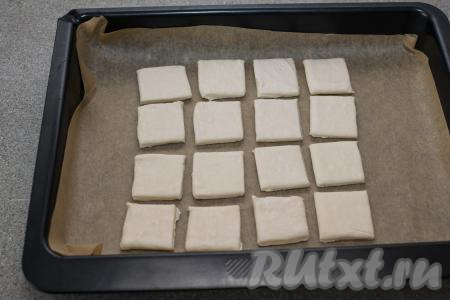 Противень застелить пергаментом. Выложить квадратики теста на пергамент на небольшом расстоянии друг от друга.&nbsp;