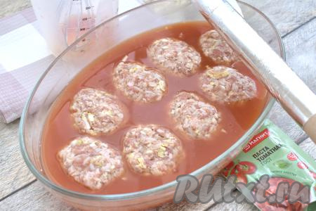 В отдельной ёмкости (у меня - мерный стакан) смешиваем 350 миллилитров тёплой воды с томатной пастой, солим, добавляем сахар, тщательно перемешиваем получившийся томатный соус. Вливаем томатный соус в форму для запекания с ленивыми голубцами. Голубцы, сформированные с пекинской капустой, должны быть практически полностью покрыты соусом, если нужно, влейте ещё 50 миллилитров воды, после этого, при необходимости, подсолите соус по вкусу. Форму накрываем фольгой и отправляем в заранее разогретую до 180 градусов духовку.