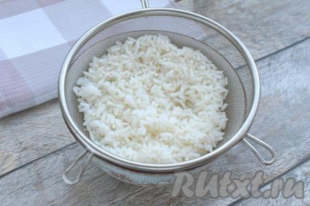 В кастрюлю наливаем 300-400 миллилитров подсоленной воды, ставим на огонь, доводим до кипения. Пока вода закипает, выкладываем рис в сито, тщательно промываем его под проточной водой. В кастрюлю с закипевшей водой выкладываем промытый рис, снова даём воде закипеть, перемешиваем и, уменьшив огонь, варим минут 15-20 (до готовности риса, он должен стать мягким, но и переваривать его не нужно). Сварившийся рис откидываем на сито, оставляем на несколько минут, чтобы стекла вода и рис остыл.
