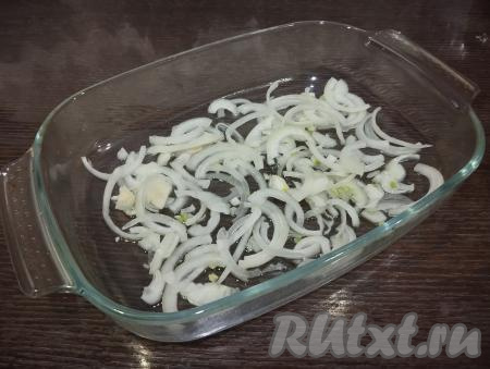 Форму для запекания смазываем растительным маслом. Равномерно раскладываем лук по дну формы.