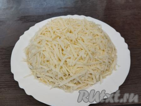 Последним слоем равномерно покрываем салат сыром, натёртым на крупной тёрке.