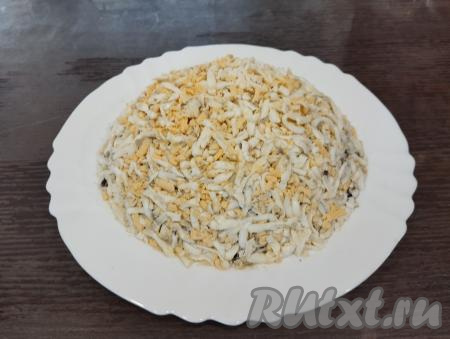 Яйца натираем на крупной тёрке, выкладываем равномерно поверх грибов.