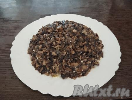 Далее равномерно выкладываем обжаренные и остывшие грибы с луком.