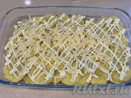 Сыр натереть на крупной тёрке. Картошку, смазанную майонезом, равномерно присыпать небольшим количеством натёртого сыра.