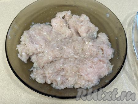 Лук и чеснок пропустить через мясорубку (или измельчить в измельчителе), добавить в миску с куриным фаршем, посолить по вкусу, хорошо перемешать.