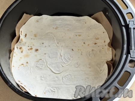 Решётку аэрогриля застелить пергаментом так, чтобы пергамент застилал и дно, и немного закрывал бока чаши аэрогриля, затем выложить первый пласт из лаваша.&nbsp;