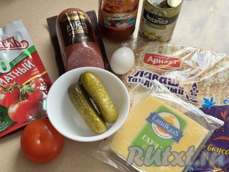 Подготовить продукты для приготовления пиццы из лаваша в аэрогриле.  Помидор вымыть. Из предложенного количества ингредиентов я приготовила 2 пиццы. Я использовала тандырный лаваш, он уже нарезан на прямоугольники, как раз по размеру чаши аэрогриля. Если вы будете использовать обычный лаваш, тогда с помощью кухонных ножниц нарежьте его на 4 пласта по размеру дна чаши вашего аэрогриля. На формирование каждой пиццы в аэрогриле потребуется 2 пласта из лаваша, равных размеру дна чаши аэрогриля.