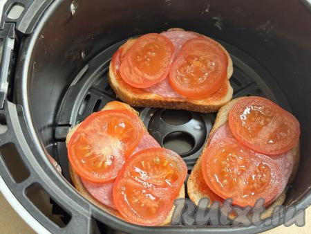 Поверх колбасы разложить кружочки помидора. Немного присолить помидоры.