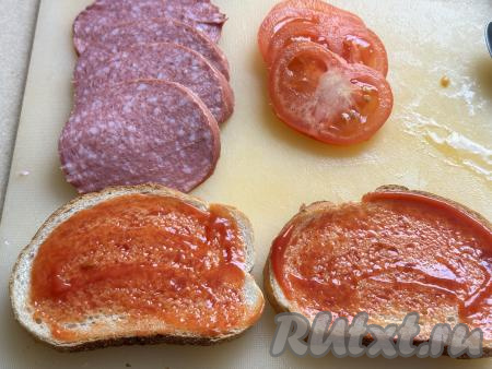 Смазать каждый ломтик батона кетчупом. Помидор вымыть. Колбасу можно взять как варёную, так и полукопчёную. Колбасу и помидор нарезать на тонкие кружочки.