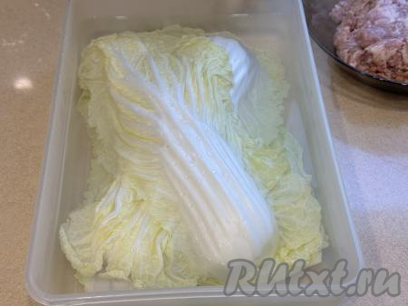 Листья пекинской капусты промыть водой. Выложить листья в плоский лоток (или в другую достаточно объёмную посуду), залить полностью кипящей водой, оставить на 5-8 минут.&nbsp;