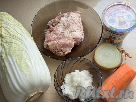 Подготовить продукты для приготовления голубцов из пекинской капусты в сметанном соусе в духовке. Рис промыть водой, лишнюю воду слить. В&nbsp;кастрюлю с кипящей подсоленной водой, выложить рис, перемешать, дать закипеть, уменьшить огонь, варить минут 20 (до готовности риса). Затем откинуть варёный рис на сито, дать стечь лишней воде. При желании можно использовать рис, оставшийся с ужина. Лук и морковь почистить. Фарш можно приготовить в домашних условиях, пропустив кусочки любого мяса (у меня - свинина), через мясорубку. Можно использовать и покупной фарш.