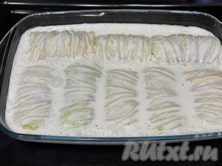 Влить сметанный соус в форму с голубцами из пекинской капусты. Соус должен практически полностью покрывать голубцы. Если необходимо, влейте ещё немного воды. Отправить форму в духовку, разогретую до 180 градусов.&nbsp;