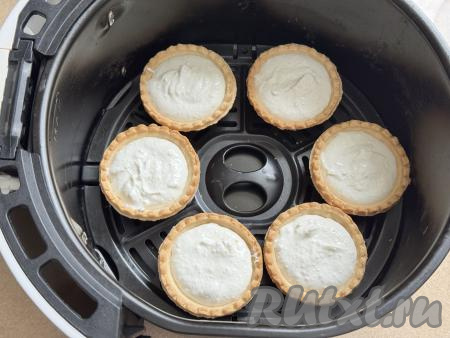 Сформировать порционные чизкейки, выложив творожную массу в песочные тарталетки. Разместить&nbsp;чизкейки в тарталетках&nbsp;на решётке аэрогриля. Всего у меня поместились 6 тарталеток, остальные я выпекала в следующий заход. Отправить чашу в аэрогриль.