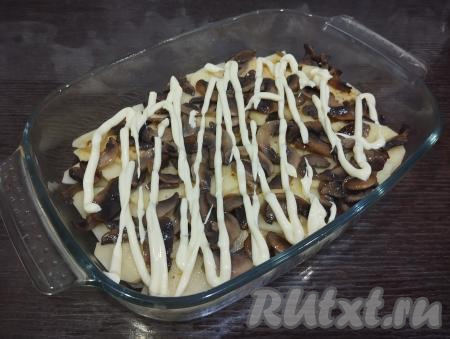 На картофель равномерно раскладываем жареные шампиньоны.&nbsp;Смазываем грибы майонезом.
