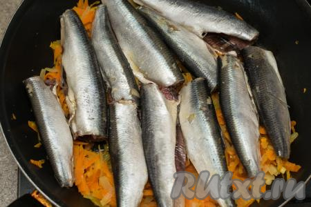 После того как морковка обжарится до мягкости, нужно выложить салаку в один слой поверх обжаренных овощей.