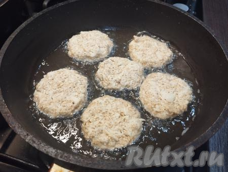 На сковороде разогреваем растительное масло, убавляем огонь до среднего. Выкладываем заготовки оладий, обжариваем с одной стороны до румяного цвета под крышкой в течение 3-4 минут (до подрумянивания снизу).