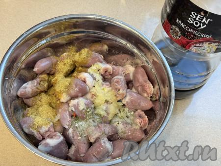 Сердечки выложить в миску, добавить соль, специи (у меня - хмели-сунели), пропущенный через пресс чеснок, влить соевый соус и растительное масло.