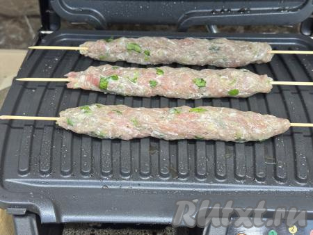 Разогреть электрогриль, выставив режим № 3 "Мясо". Смазать панели электрогриля растительным маслом. Выложить на нижнюю панель электрогриля 3 шпажки с люля-кебабами.