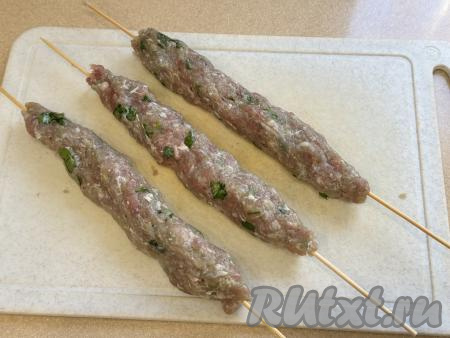 Охлаждённый фарш разделить на 7 частей. Из каждой части фарша сформировать люля-кебаб на шпажке, как на фото. Чтобы фарш не прилипал к рукам, можно слегка смочить руки водой.