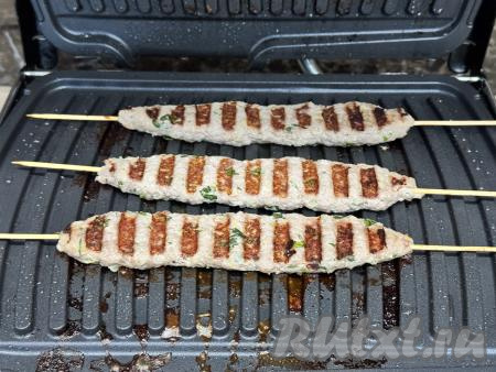 Накрыть электрогриль верхней панелью, прижав немного мясо. Готовить люля-кебабы на электрогриле примерно 8 минут, продолжительность жарки зависит от мощности вашего гриля. Если готовите люля в первый раз, тогда можно проверить готовность, разрезав один люля-кебаб и посмотрев на разрез. Если в разрезе мясо без розового оттенка, значит оно готово.