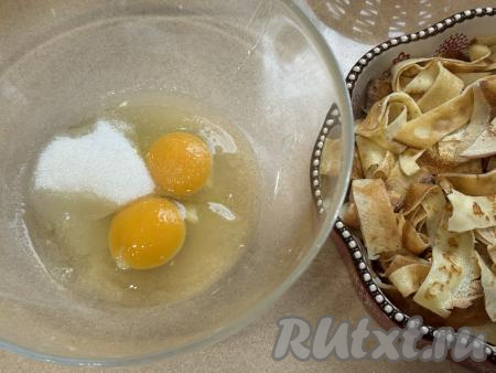 Форму для запекания (я использовала форму диаметром 19 сантиметров)&nbsp;смазать изнутри растительным маслом. Выложить блинные полоски в форму. Для получения заливки соединить в миске яйца и сахар.