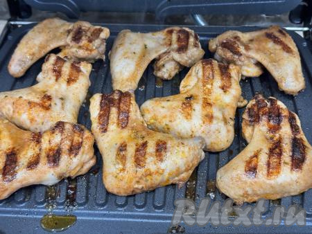 Накрыть электрогриль второй створкой и готовить крылья 10 минут.