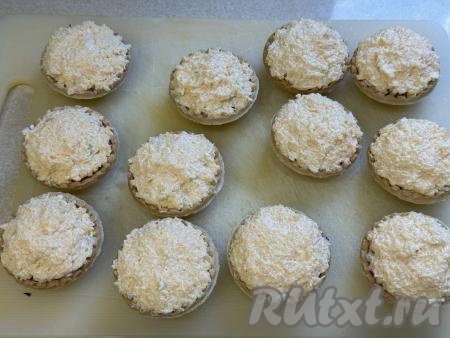 Получившуюся массу с помощью ложки выложить в тарталетки поверх основной начинки в виде сырной шапочки.