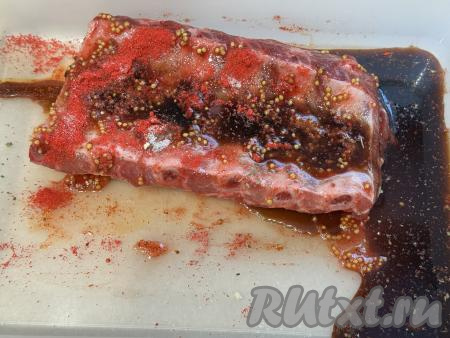 В небольшой ёмкости соединить горчицу, растительное масло и соевый соус, перемешать до однородности, получившуюся смесь влить поверх мяса в лоток. Несколько раз перевернуть свиные рёбрышки, покрывая их соевым соусом, горчицей и маслом со всех сторон.