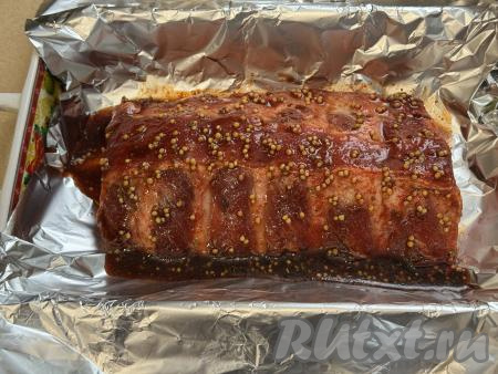 Жаропрочную форму застелить фольгой, сложенной вдвое, так, чтобы края фольги свисали с краёв формы. В форму, застеленную фольгой, выложить замаринованные рёбра, влить поверх мяса оставшийся маринад.&nbsp;