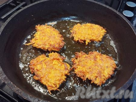 Лопаткой аккуратно переворачиваем драники из моркови на другую сторону, снова накрываем крышкой и жарим до подрумянивания с другой стороны (примерно в течение 2-3 минут).