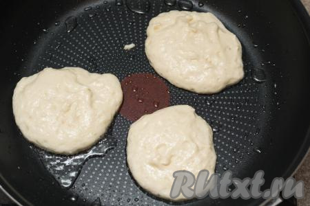 В сковороду влить немного растительного масла, хорошо разогреть, после этого выкладывать по 1 столовой ложке теста в виде округлых оладий.