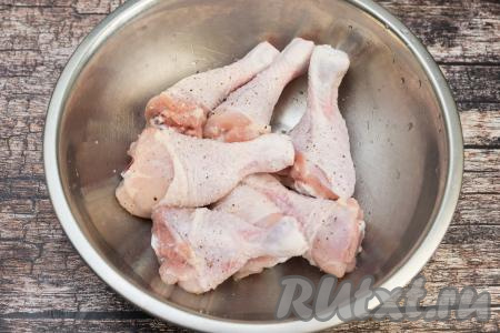 Куриные ножки выкладываем в миску, солим, перчим. Тщательно перемешиваем, втирая руками специи в ножки со всех сторон.