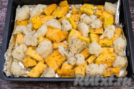 Противень для запекания застелить пищевой фольгой (или пергаментом), выложить подготовленные кусочки тыквы. Рядом с тыквой разместить отваренную цветную капусту. Я капусту ещё присыпала сверху прованскими травами.
