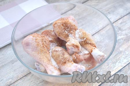 Куриные ножки моем, обсушиваем, выкладываем в миску, всыпаем соль и специи по вкусу (в качестве специй я добавила паприку, 1 чайную ложку приправы для курицы и 0,3 чайной ложки сушёного чеснока). Тщательное перемешиваем куриные ножки, покрывая их специями со всех сторон.