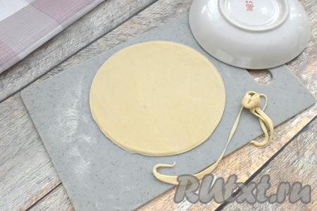 Тесто делим на 12 равных частей. На присыпанной мукой поверхности каждую часть теста раскатываем в лепёшку диаметром примерно 15 сантиметров. Чтобы края лепёшки были ровными, я сверху прикладывала блюдце подходящего диаметра и отрезала лишнее тесто.