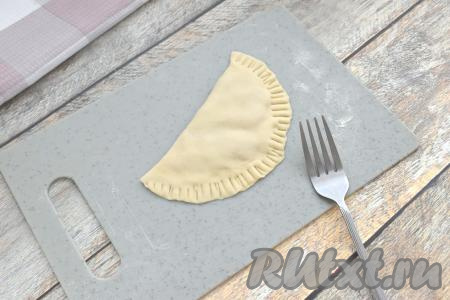 Накрываем начинку свободной стороной лепёшки, плотно скрепляем края и дополнительно фиксируем край вилкой. Таким же способом лепим все чебуреки. Всего я сформировала 13 чебуреков (один чебурек получился из остатков обрезанного теста).