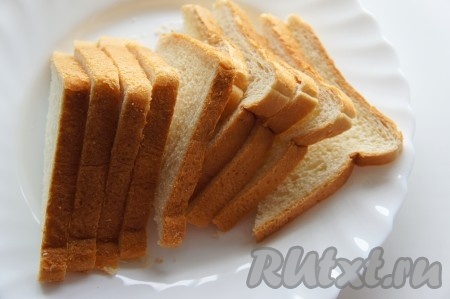 Разрежьте каждый кусок тостового хлеба по диагонали, получатся треугольники. Для большей нежности тостов можете удалить корочки.

