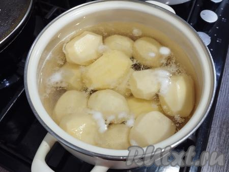 Первым делом очищенный картофель выкладываем в кастрюлю, заливаем полностью водой, солим и отвариваем до готовности (в течение 25-30 минут с момента закипания воды, готовые картошины будут легко прокалываться ножом).