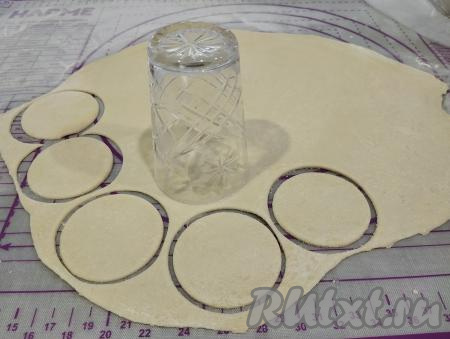 По прошествии 15 минут тесто станет более податливым, эластичным. Делим тесто на 4 части. На присыпанной мукой поверхности раскатываем каждую часть теста скалкой до толщины примерно 2 миллиметра, вырезаем кружочки при помощи кружки или стакана. Тесто приятное в работе, оно хорошо раскатывается, не рвётся.