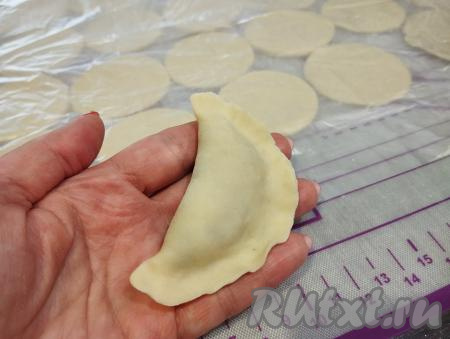 Соединяем края каждого кружка над начинкой, крепко скрепляя края вареника руками.