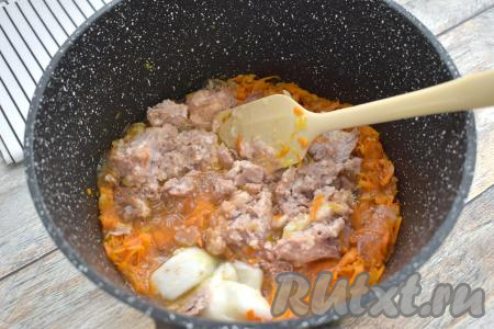 После того как морковка станет мягкой, добавляем к обжаренным овощам тушёнку (я добавила тушёнку вместе с жиром, но при желании жир можно убрать). Перемешиваем овощи с тушёнкой и обжариваем 5 минут, разбивая кусочки мяса.