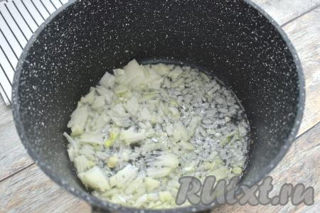 В кастрюле с толстым дном (или в глубокой сковороде) прогреваем растительное масло, выкладываем мелко нарезанный лук и обжариваем его на среднем огне, иногда помешивая, в течение 3-4 минут (до мягкости лука).