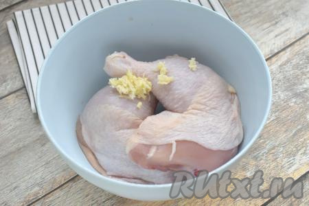 Куриные окорочка моем, обсушиваем, выкладываем их в достаточно глубокую миску. К окорочкам добавляем натёртые на мелкой тёрке (или пропущенные через пресс) очищенные зубчики чеснока.