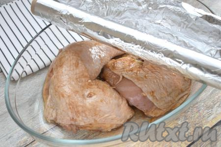 Куриные окорочка, замаринованные в соевом соусе, выкладываем в один слой в жаропрочную форму для запекания. Если в миске, в которой мариновалось мясо, останется соус, его нужно будет влить поверх окорочков. Форму плотно накрываем фольгой и отправляем в духовку, прогретую до 190 градусов.