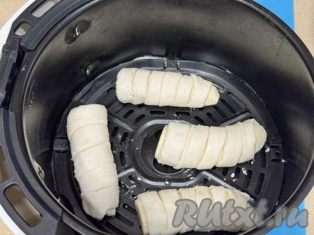Выложить бананы, завёрнутые в слоёное тесто, на решётку аэрогриля. Все слойки у меня за раз не поместились в чашу аэрогриля, поэтому я выпекала в несколько заходов.